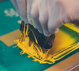 Screen printing yellow ink onto fabric